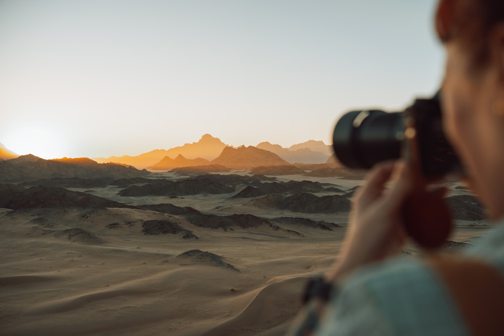 카메라로 사막 사진을 찍는 여자