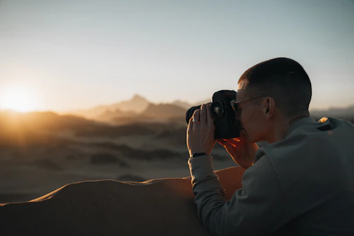 A cinematic photo shoot capturing a dramatic desert sunset with golden light