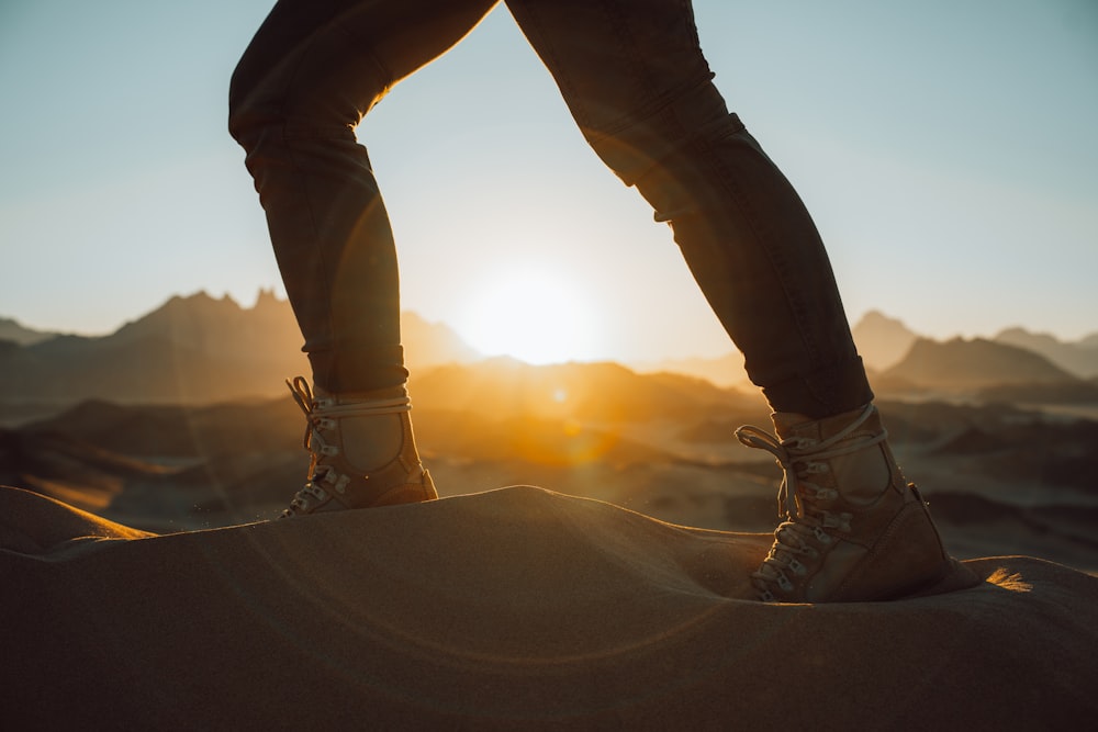 a person standing on top of a sand dune