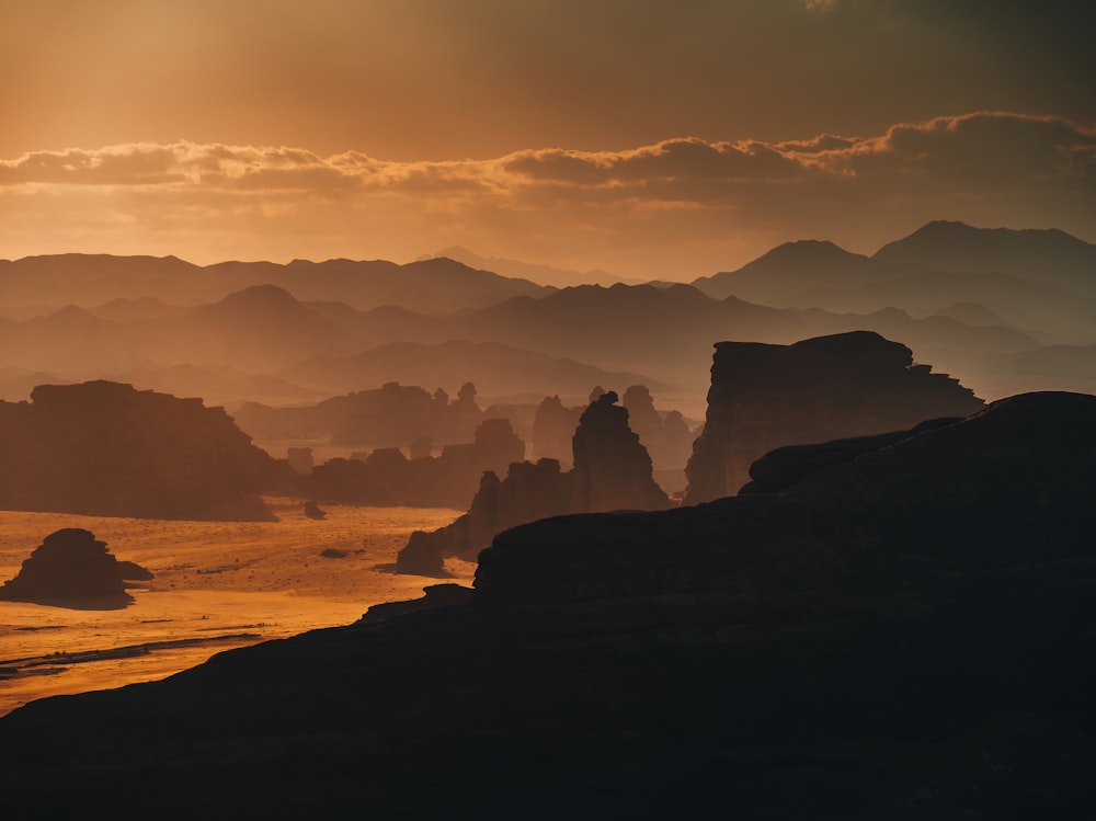 the sun is setting over a mountain range