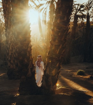 a woman is standing between two palm trees