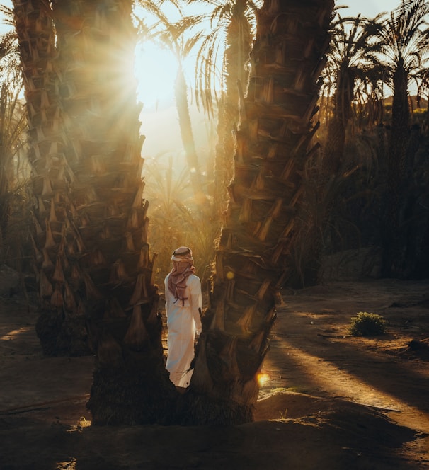 a woman is standing between two palm trees