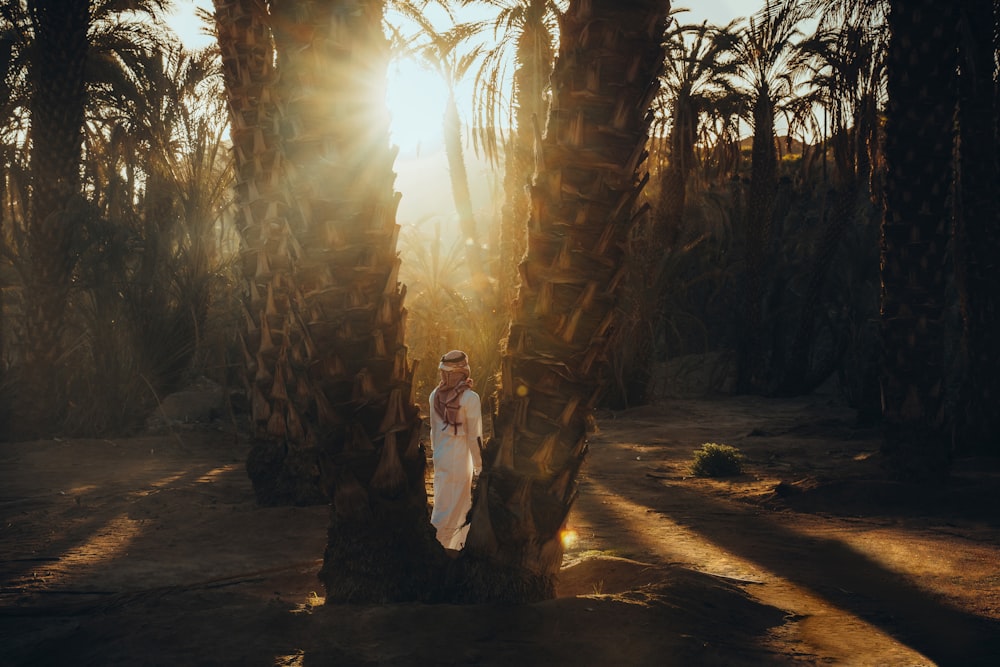 a woman is standing between two palm trees