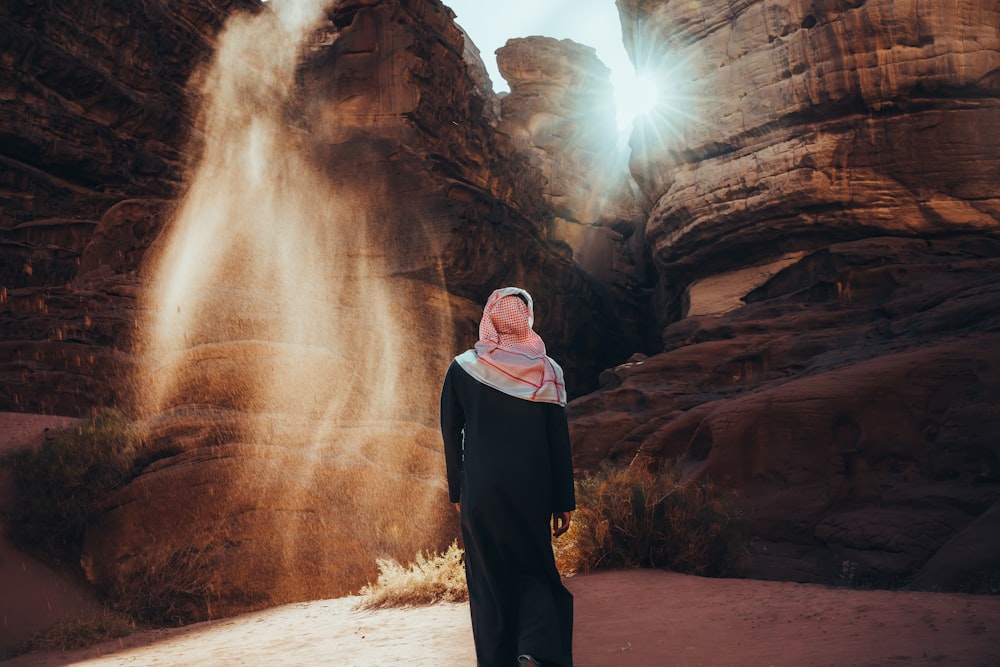 a person standing in front of a rock formation