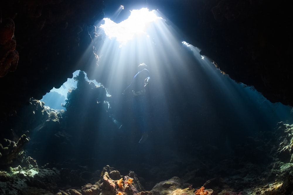 Ein Sonnenstrahl scheint durch eine Höhle im Ozean