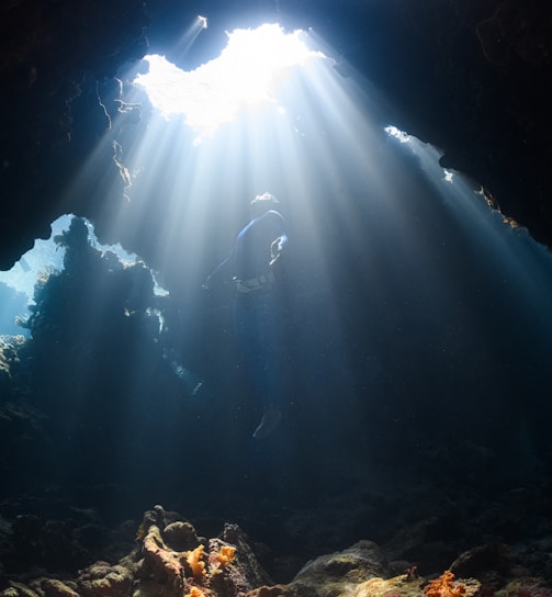 a sunbeam shines through a cave in the ocean