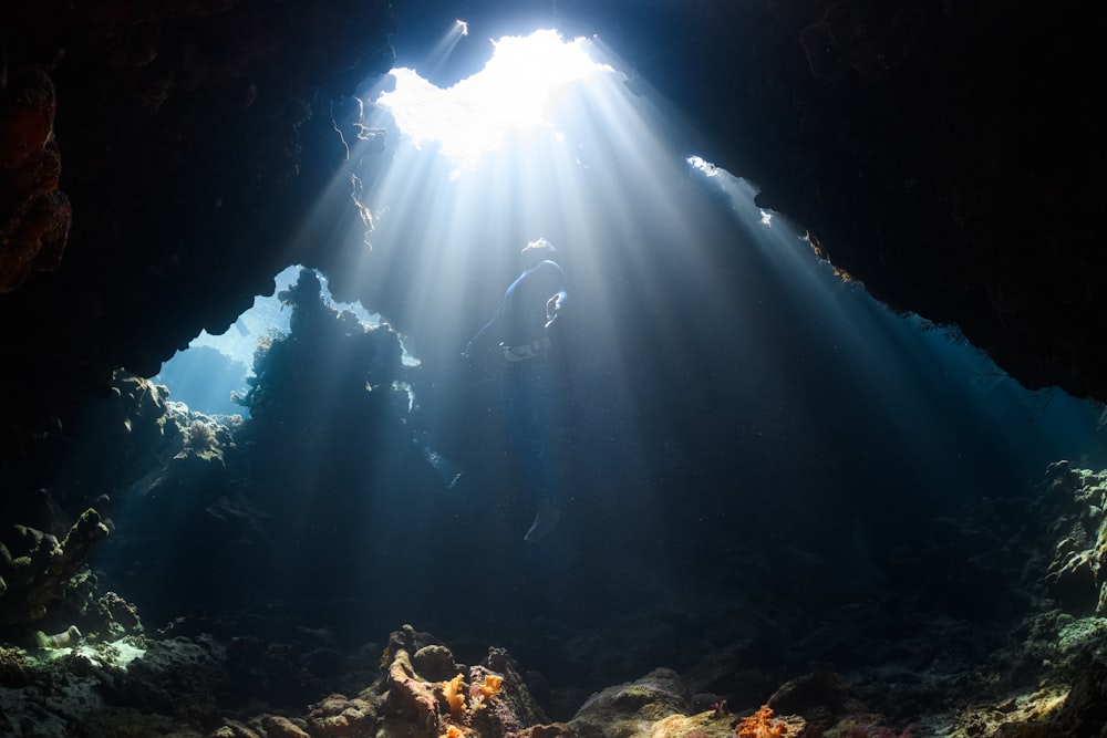 Un rayon de soleil brille à travers une grotte dans l’océan