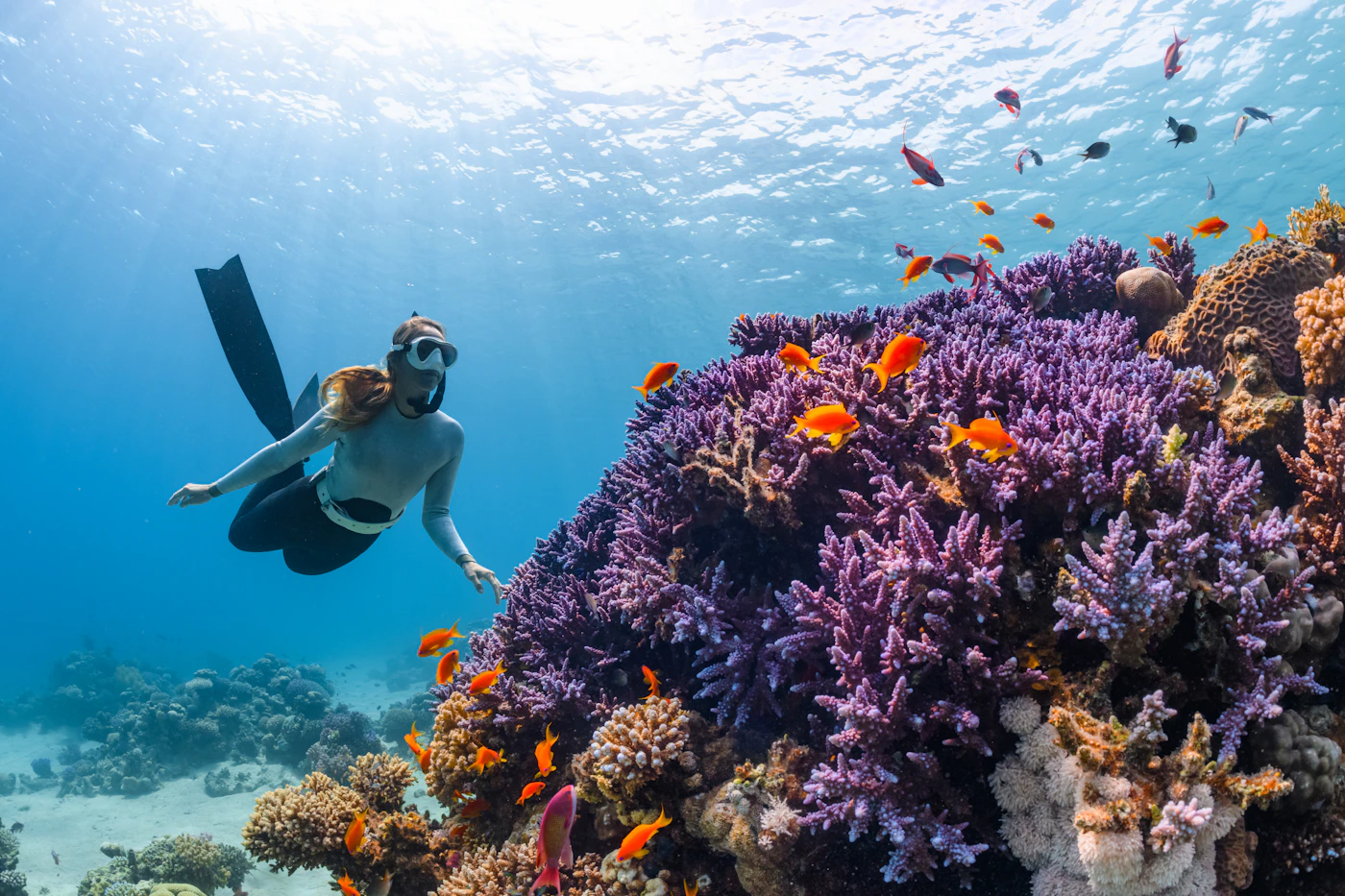 Diver working in bright open water near the surface, representing the pressure and equipment hazards behind common diving injuries