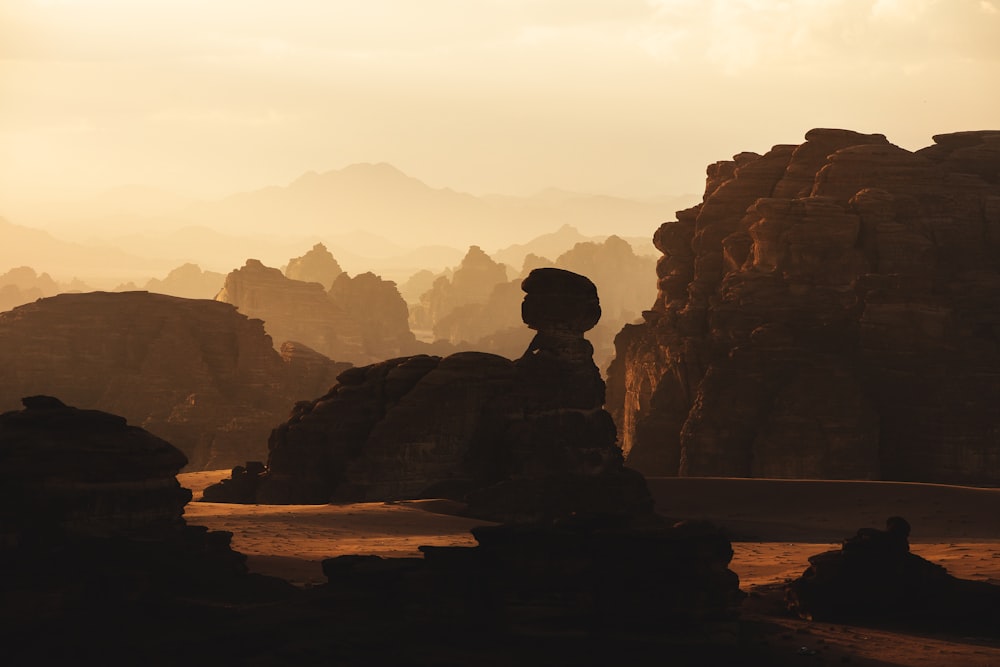 una formación rocosa en el desierto con montañas al fondo