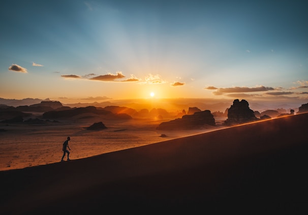 a person standing on top of a sandy hill