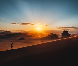 a person standing on top of a sandy hill