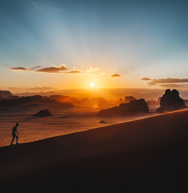 a person standing on top of a sandy hill