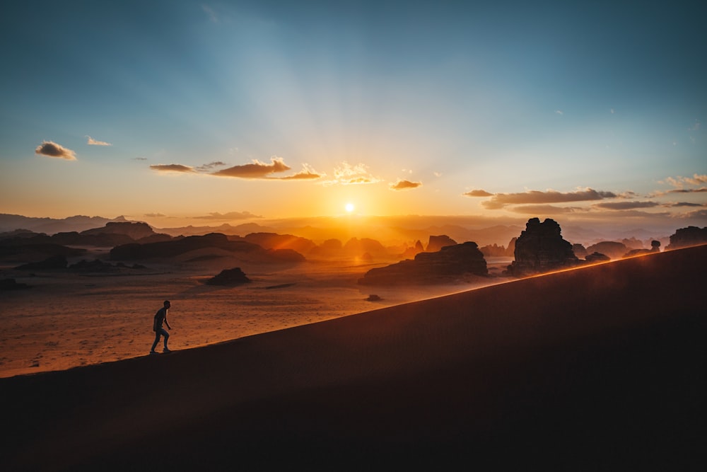 a person standing on top of a sandy hill