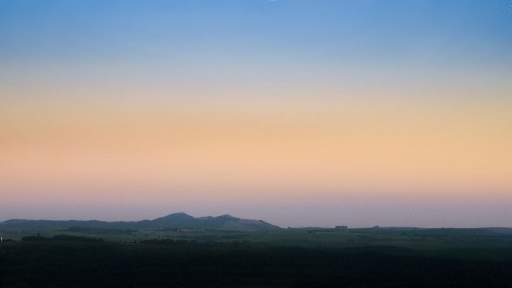 a distant view of a mountain range at sunset