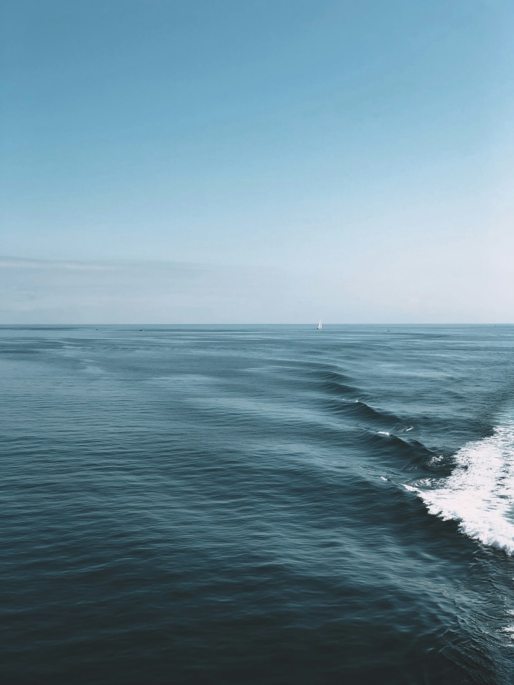 a large body of water with a boat in the distance