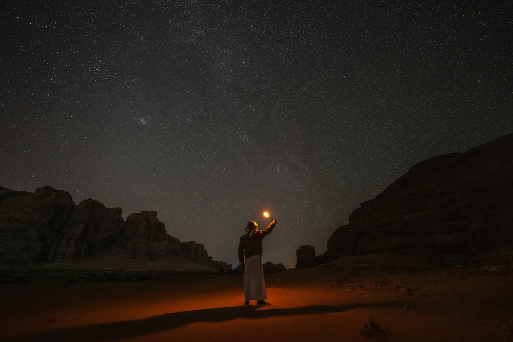 Una persona in piedi nel deserto con una lanterna