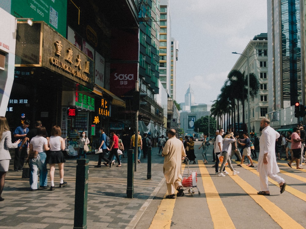 a group of people walking down a street next to tall buildings