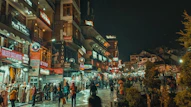 a group of people walking down a street next to tall buildings