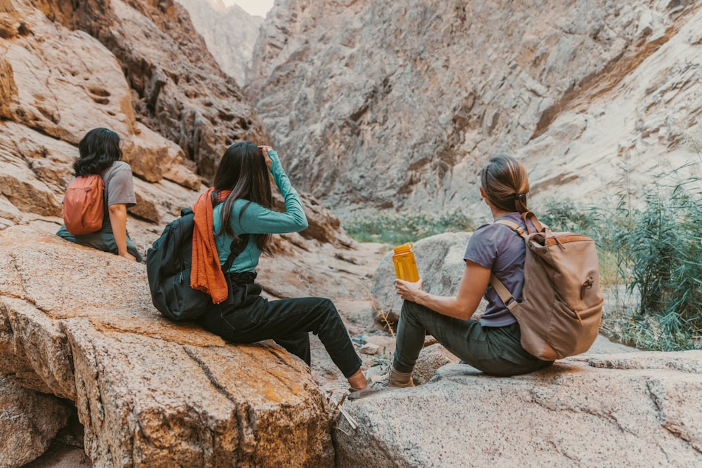 a group of people sitting on top of a rock