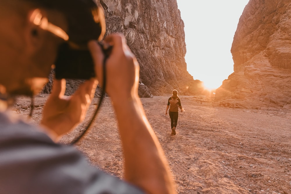 a man taking a picture of a woman in the desert