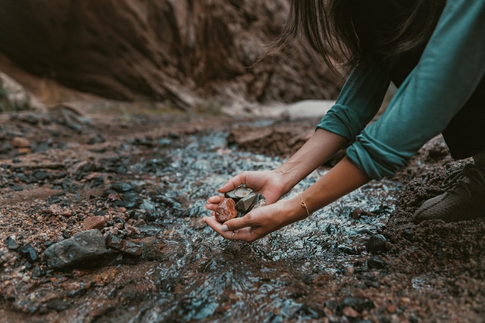 una persona inginocchiata e con una roccia tra le mani