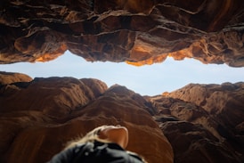 a person looking out from a cave in the desert