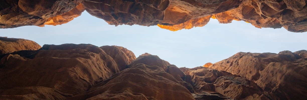 a person looking out from a cave in the desert