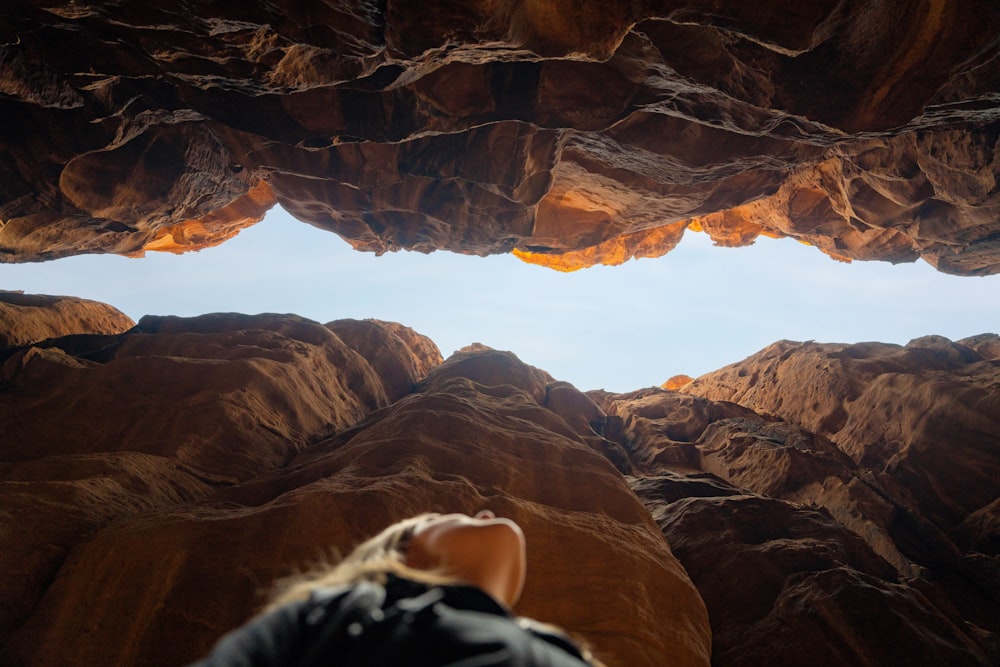 a person looking out from a cave in the desert