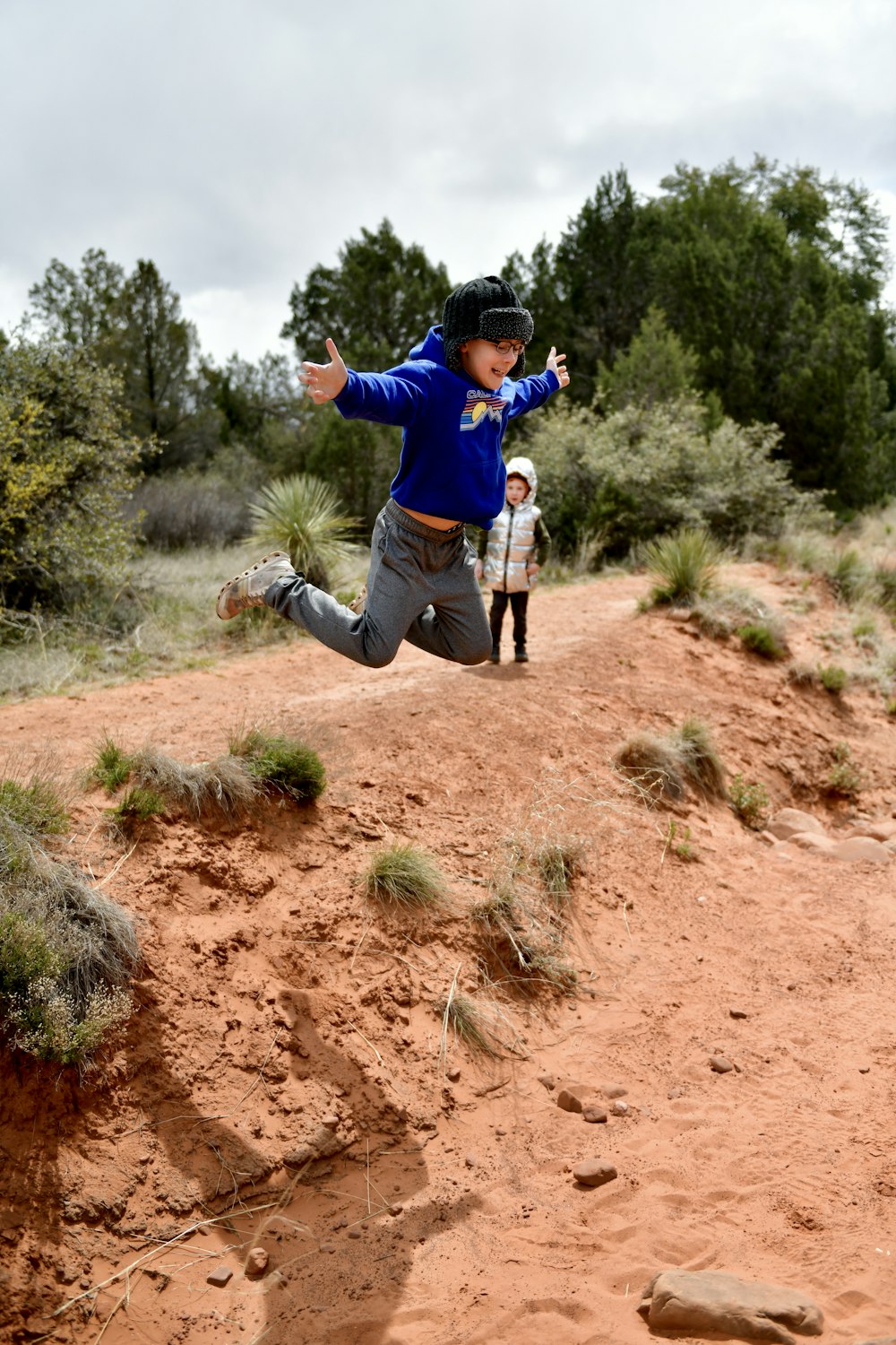 a person jumping in the air on a dirt hill