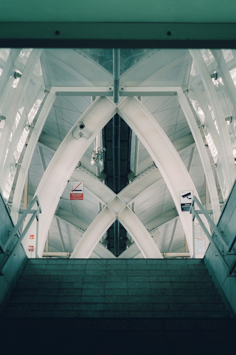 uma escada rolante em uma estação de trem com vista para o teto