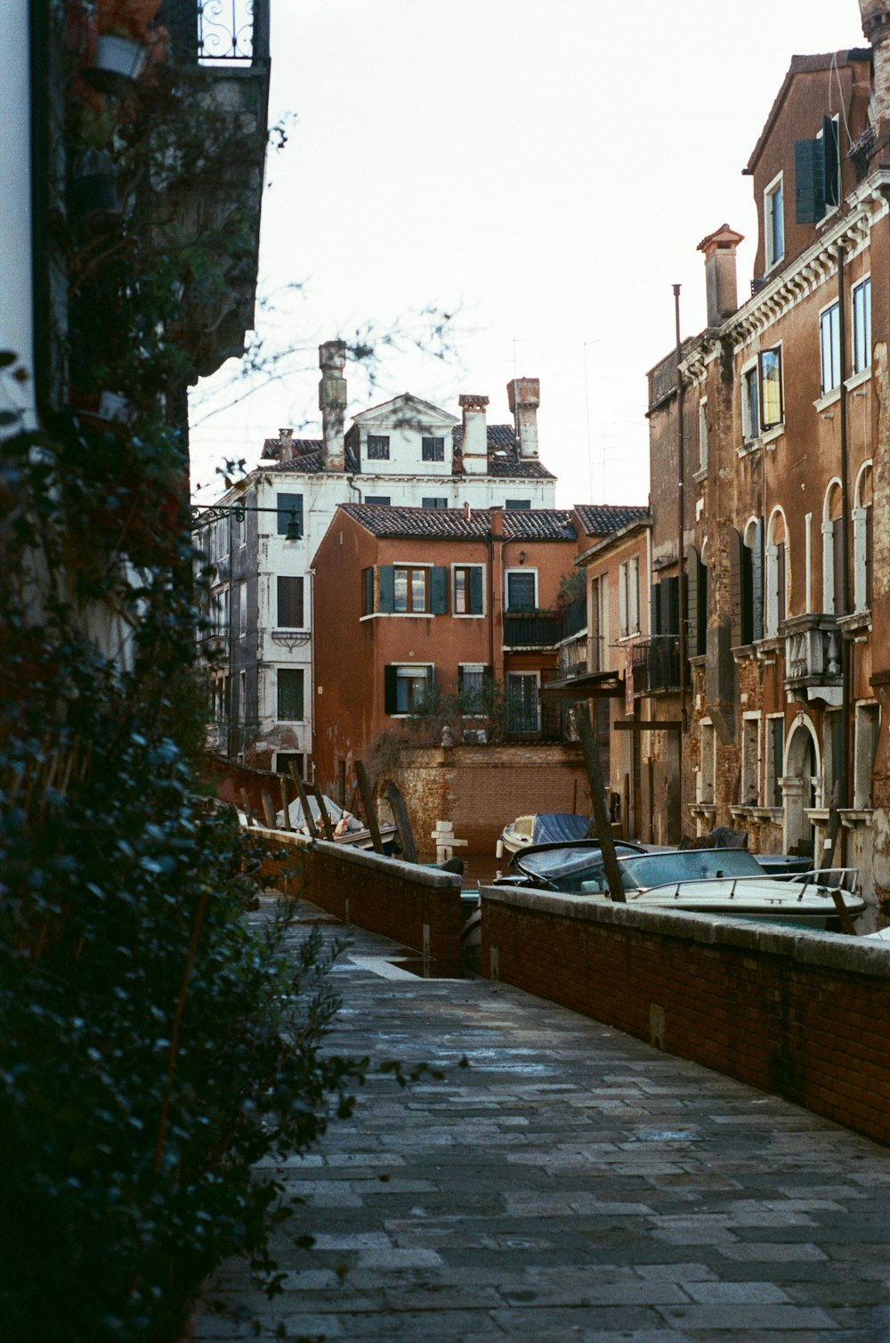 Una estrecha calle de ladrillo con edificios al fondo