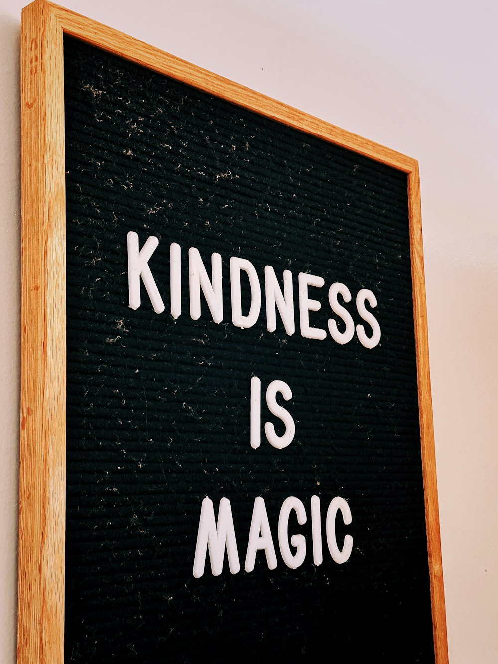 a black and white sign that says kindness is magic
