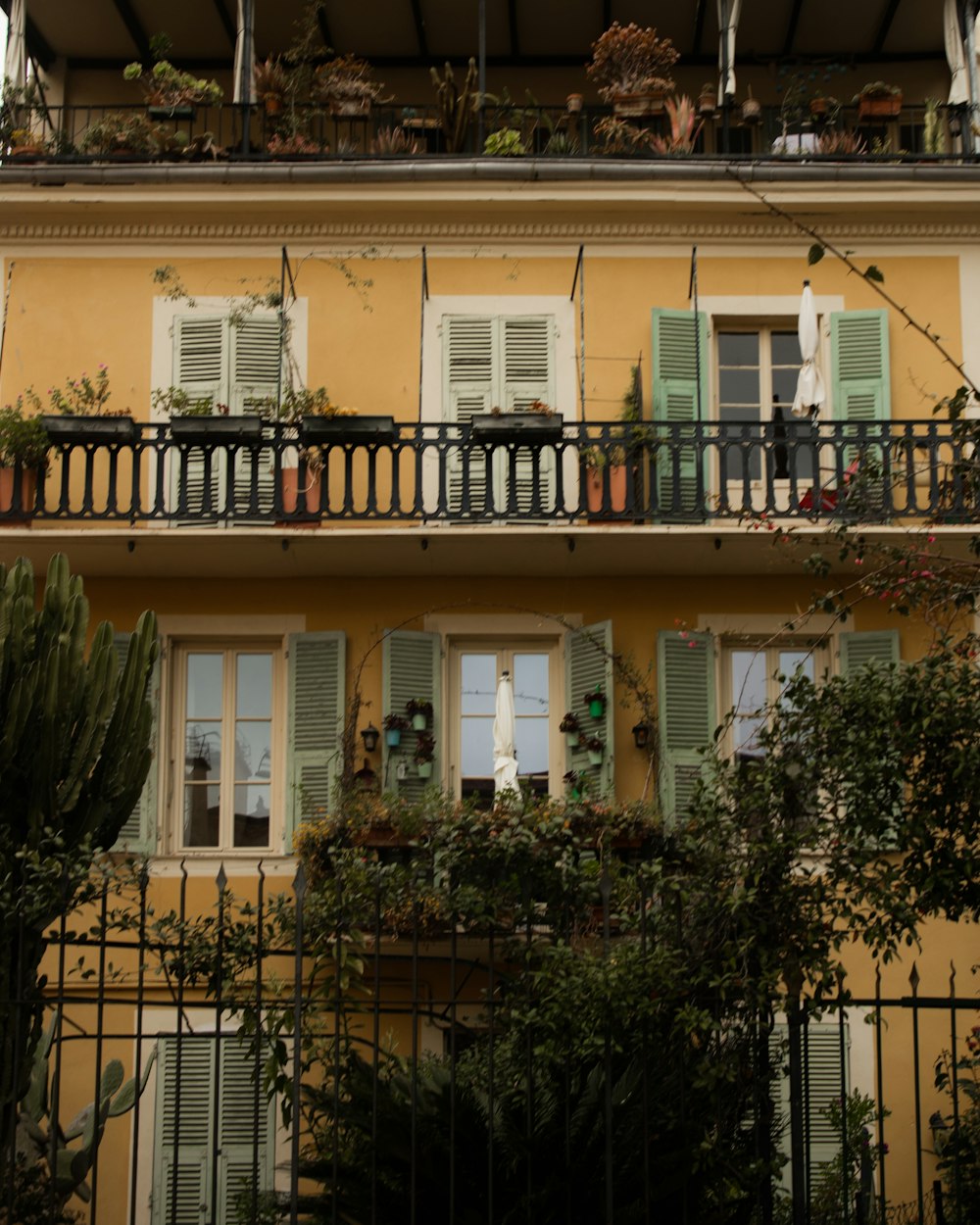 a yellow building with green shutters and balconies