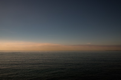 Subtle macroeconomic chart overlay on a calm ocean horizon, reflecting long-term growth.