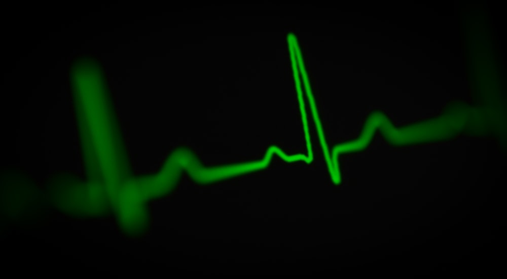 a green heart beat on a black background