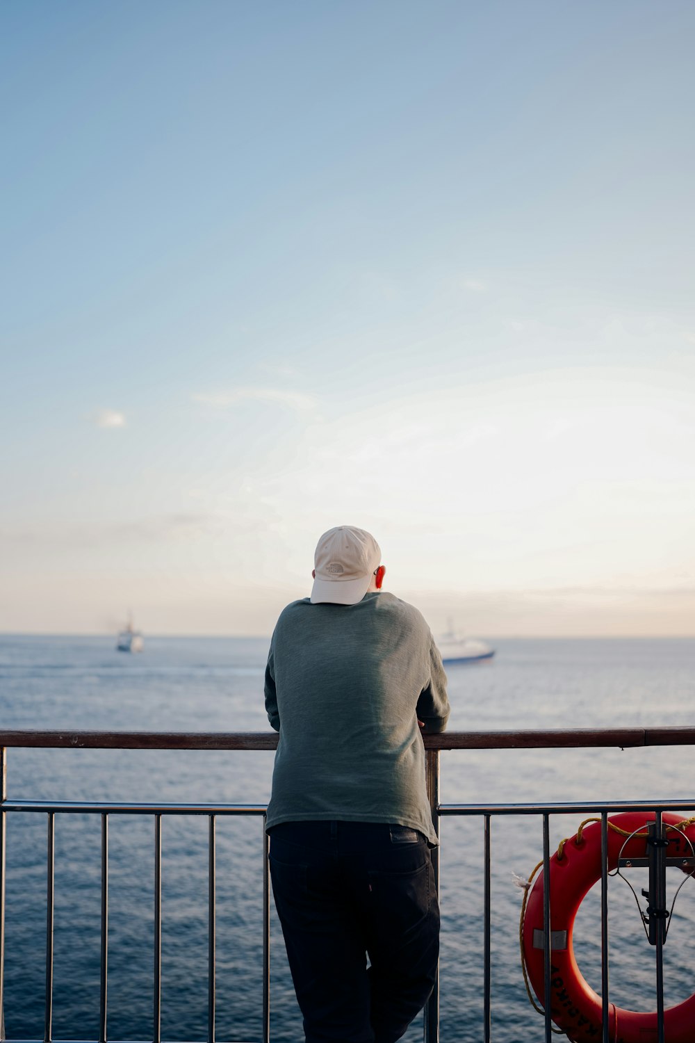 a man standing on a railing looking out at the ocean