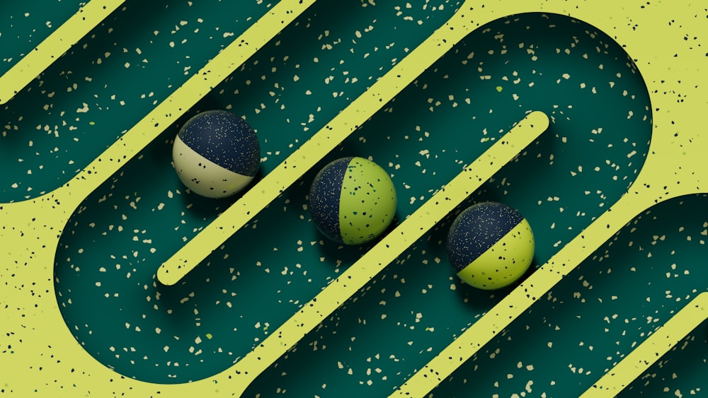 three green and blue balls sitting on a green surface