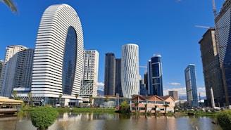 a lake in front of a city with tall buildings