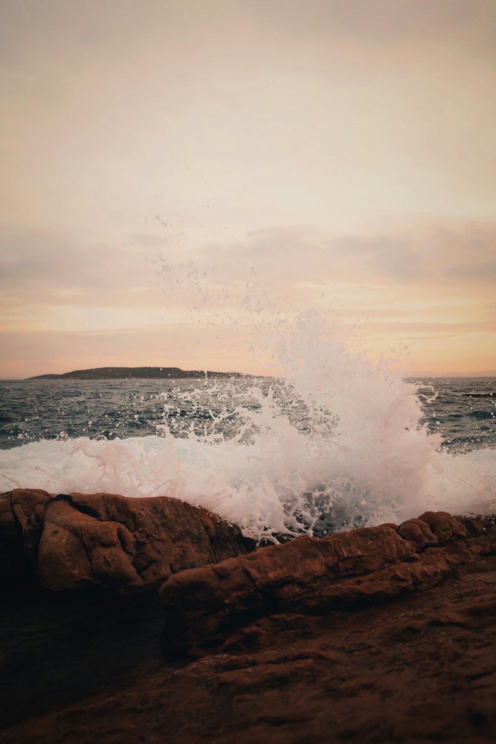 a large wave crashing into the shore of the ocean