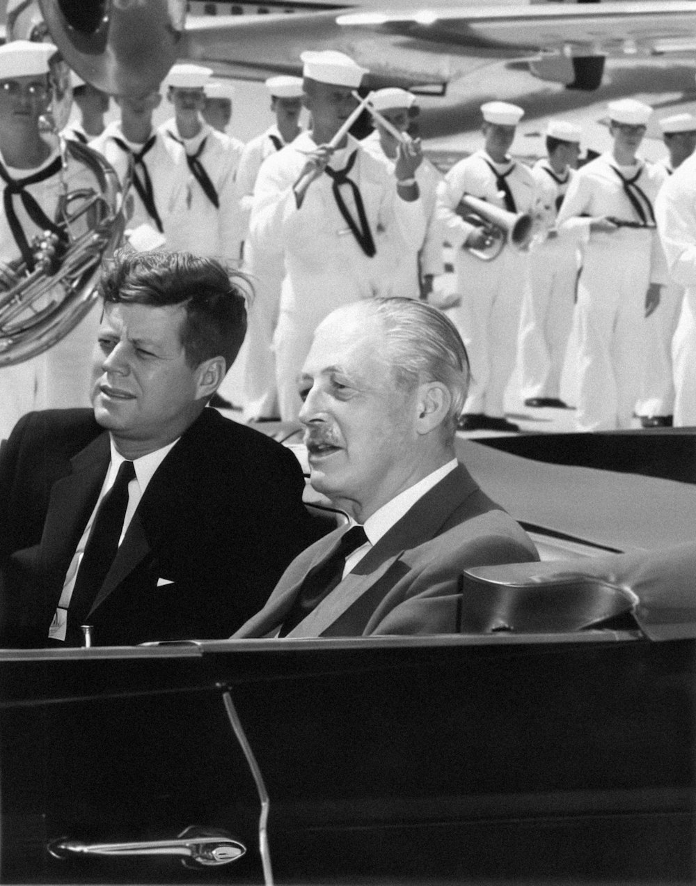 a black and white photo of two men in a car