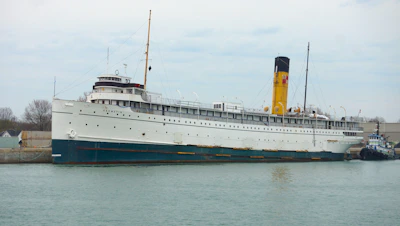 Aged postcard depicting a steamship docked at a foggy harbor.