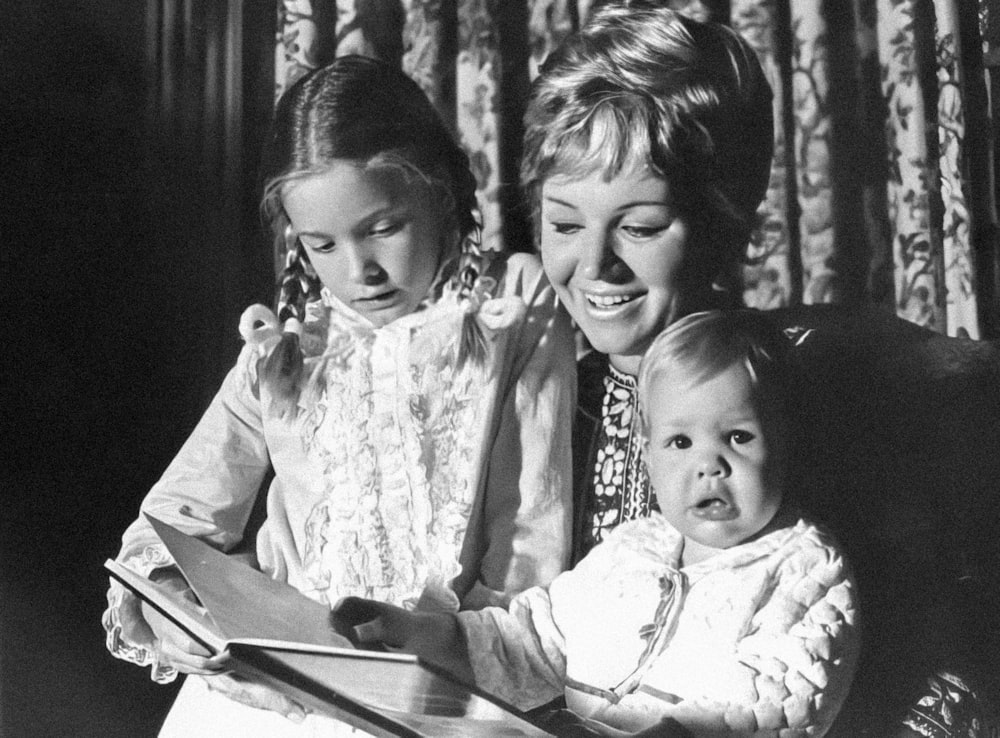 a black and white photo of two women and a baby