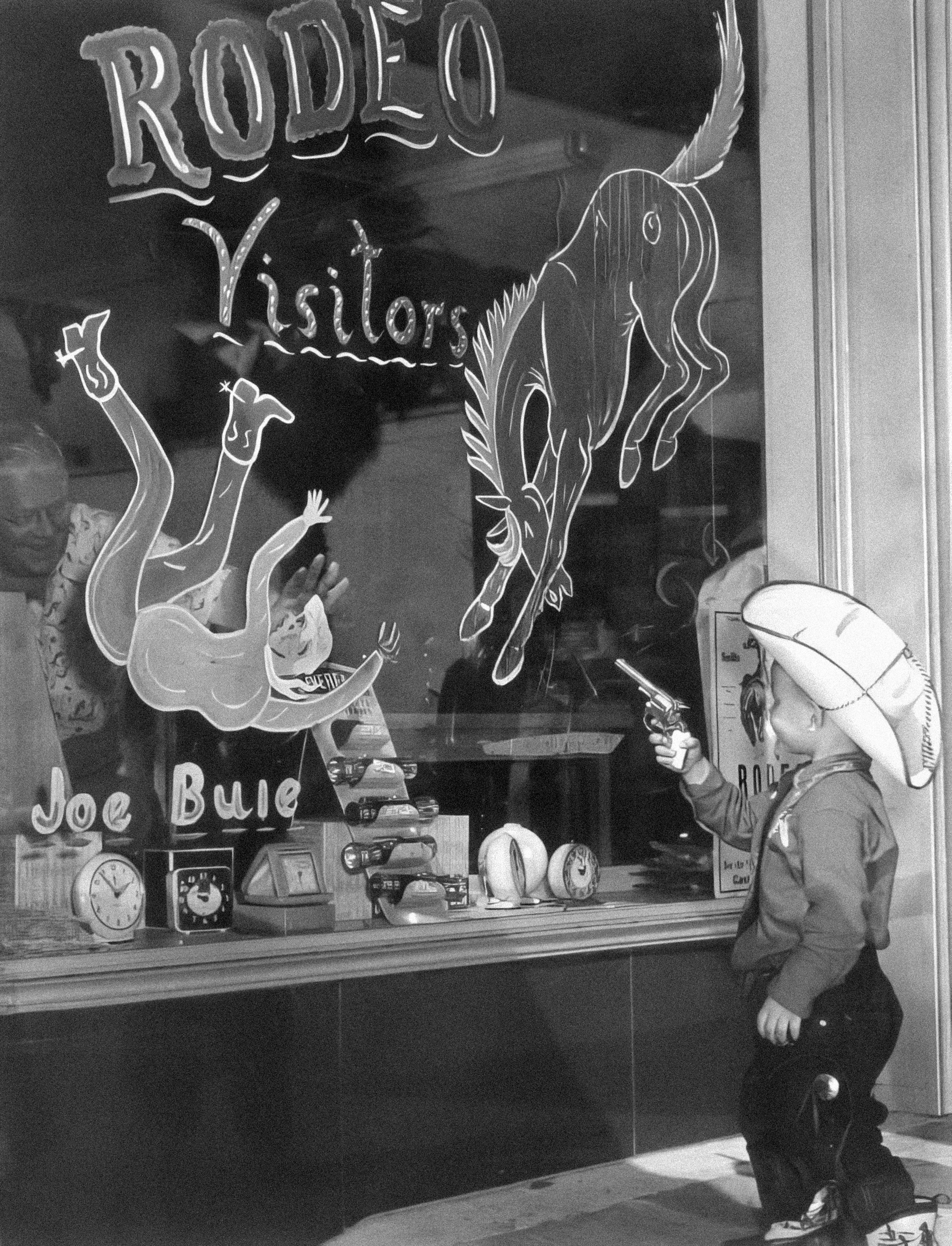 A little boy that is standing in front of a store