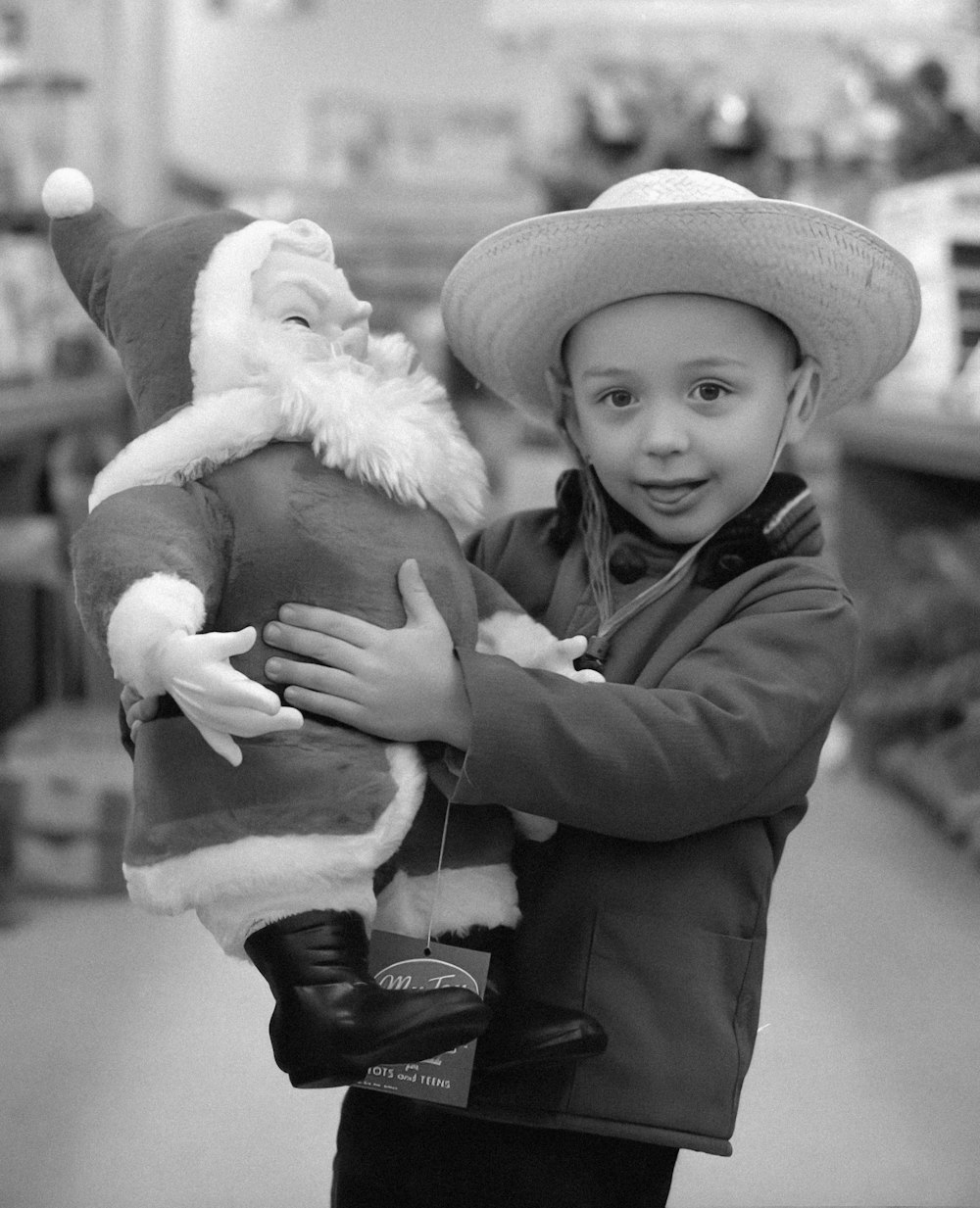 a young boy is holding a stuffed santa clause