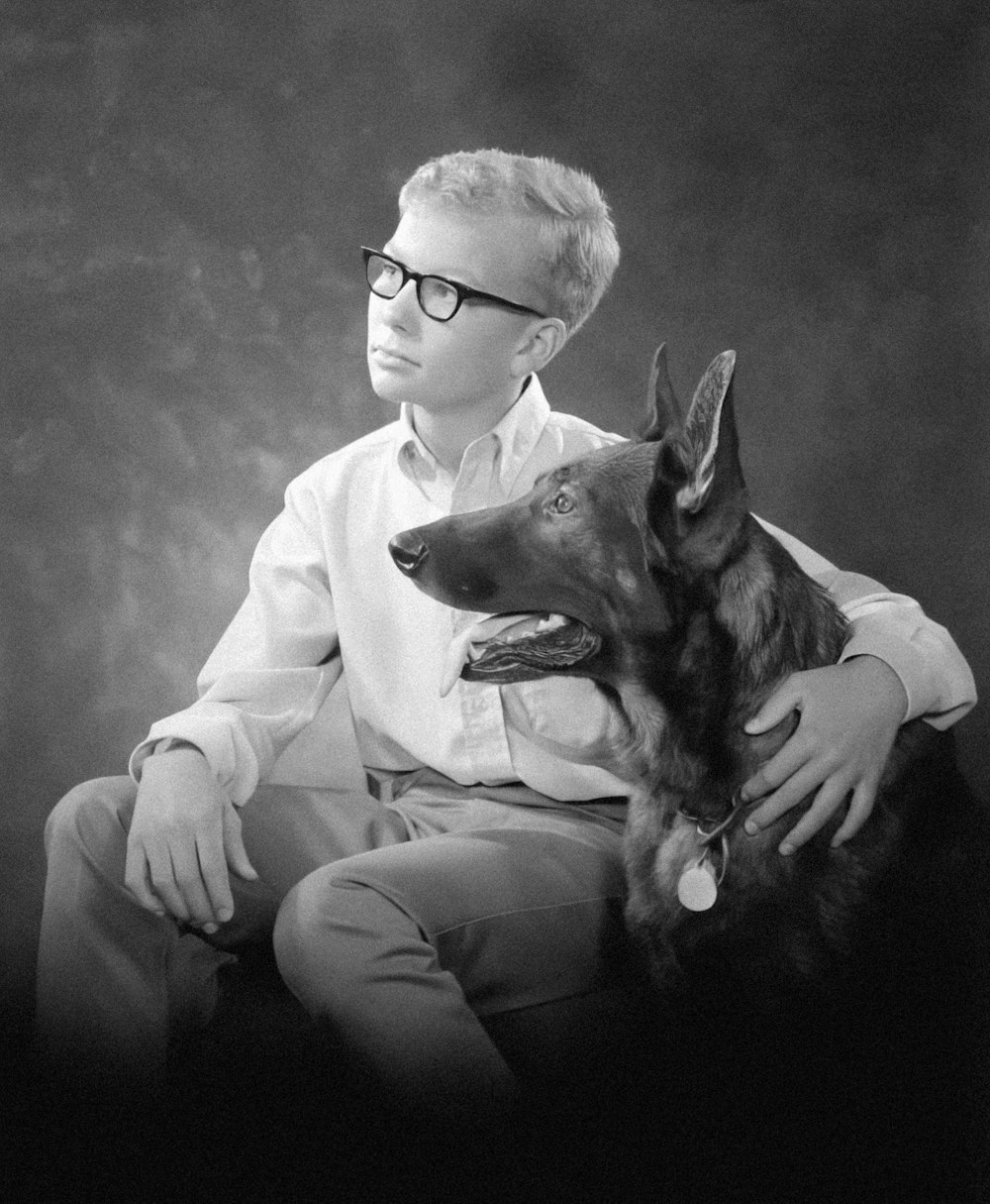 a black and white photo of a man and his dog