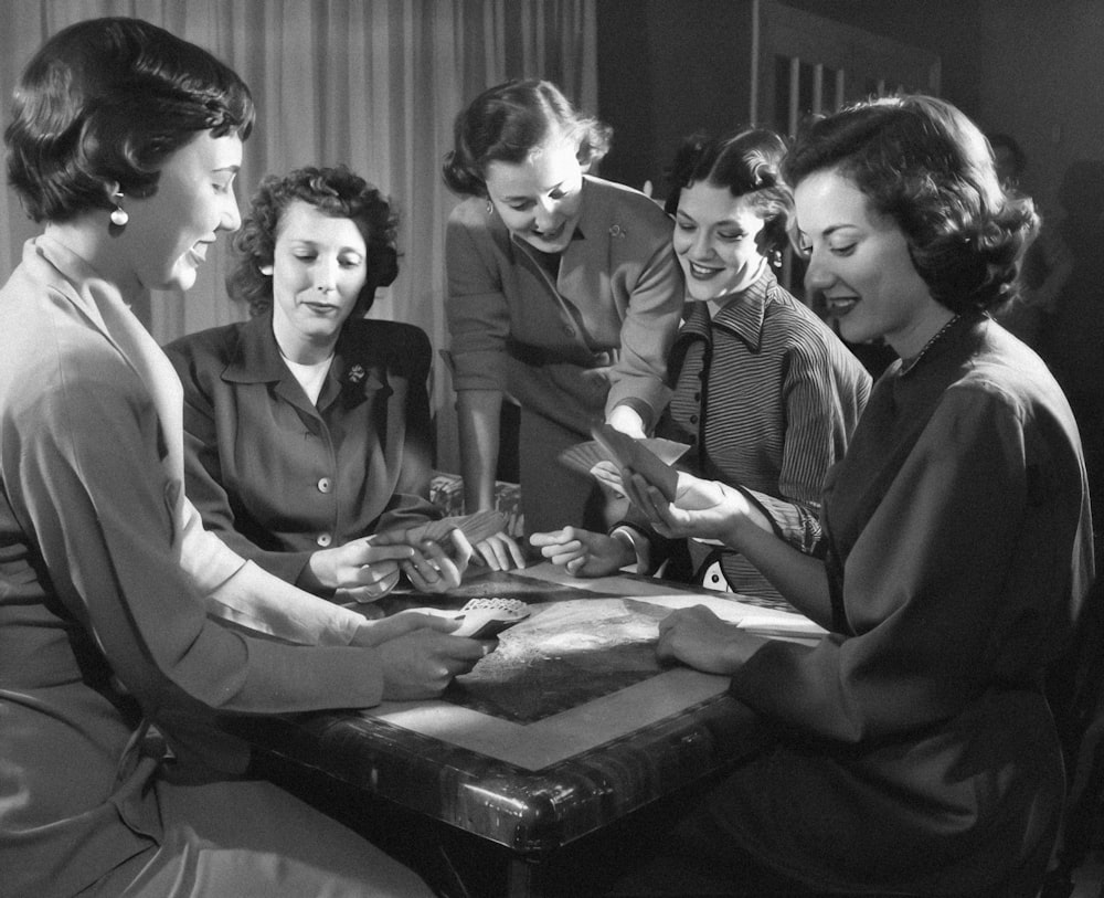 a group of women sitting around a wooden table
