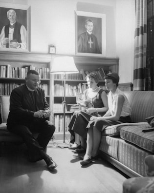 Photograph of authors gathered in a cozy library setting discussing a new project.