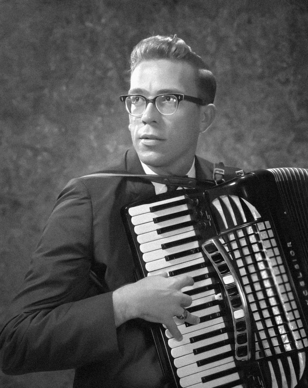 a man with glasses is playing an accordion