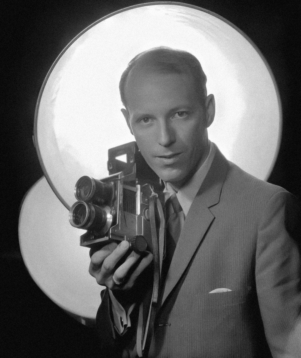 a man in a suit holding a camera