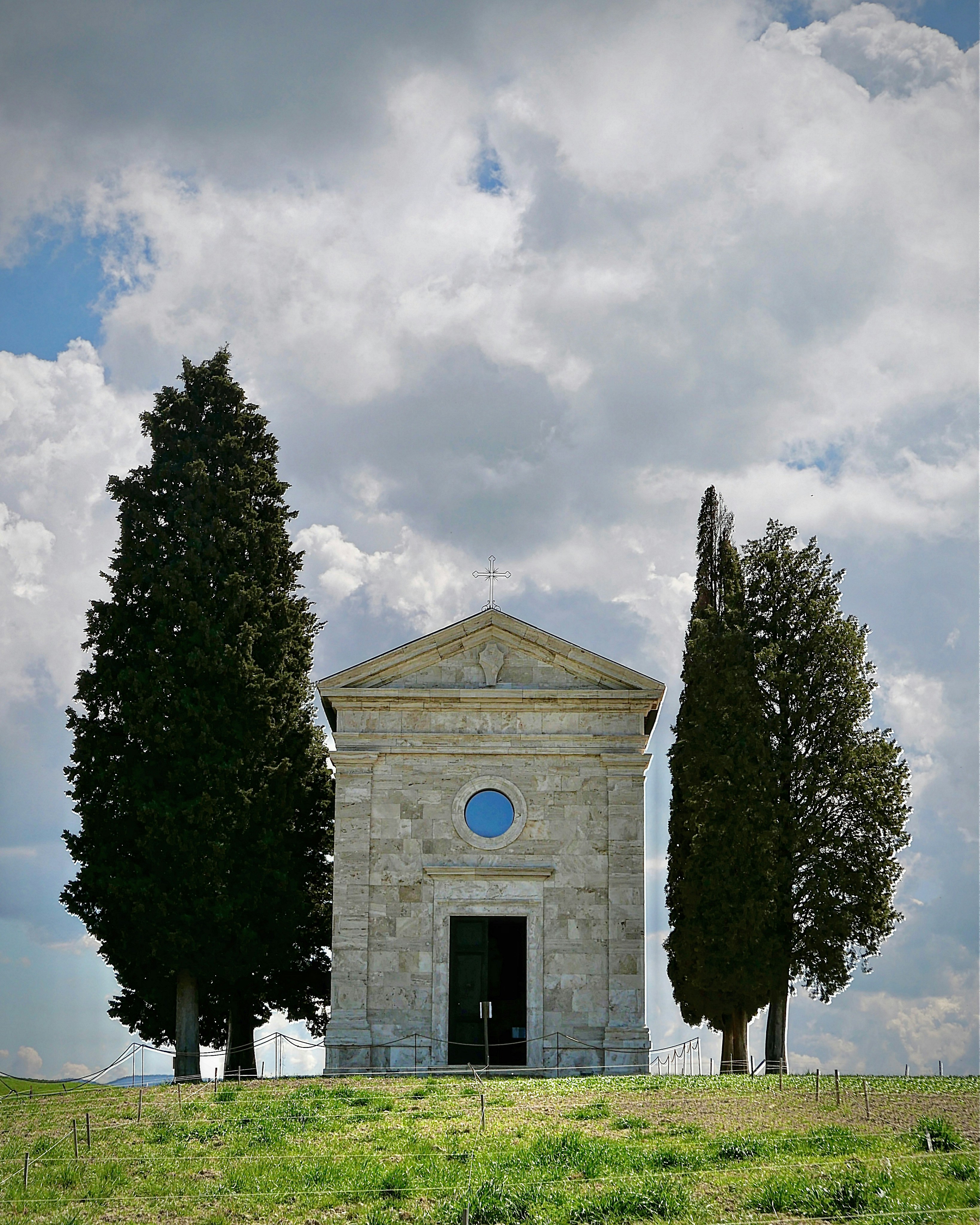a small stone building with trees in front of it
